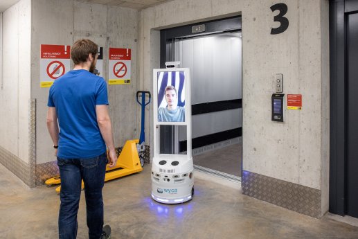 c_KONE__Zebrabox_Winterthur15_Nutzer_mit_Roboter_am_Aufzug.jpg